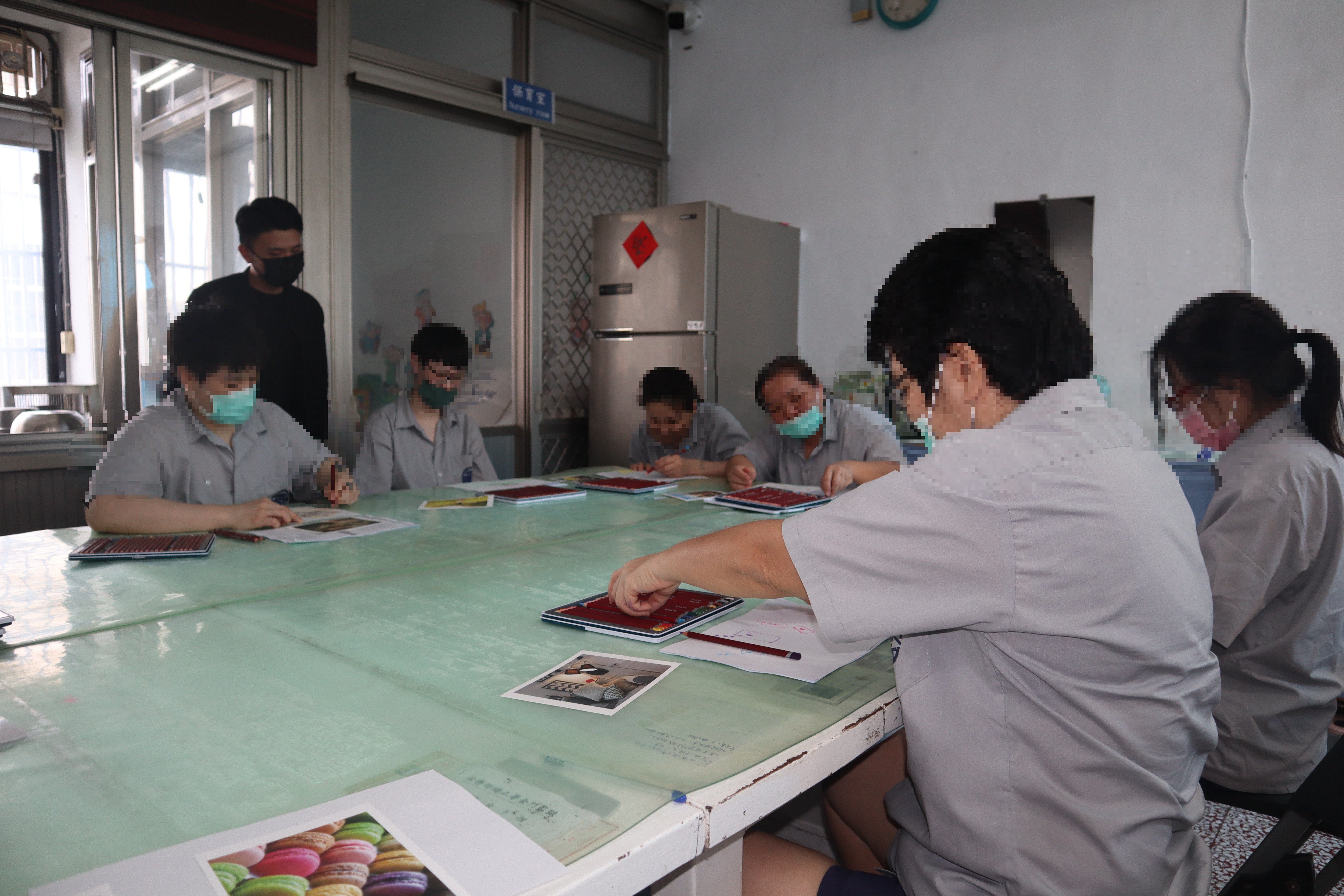 收容人正在嘗試用左手描繪牌卡