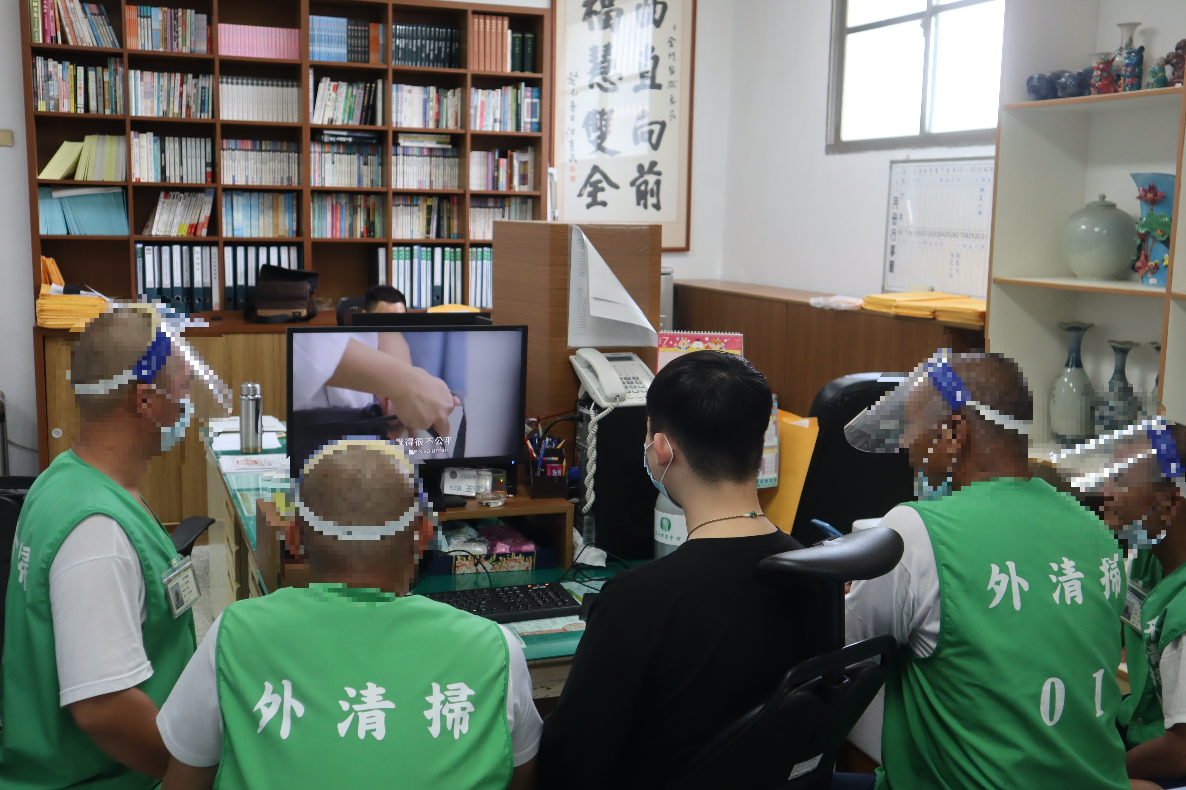 Social workers watch promotional video with inmates