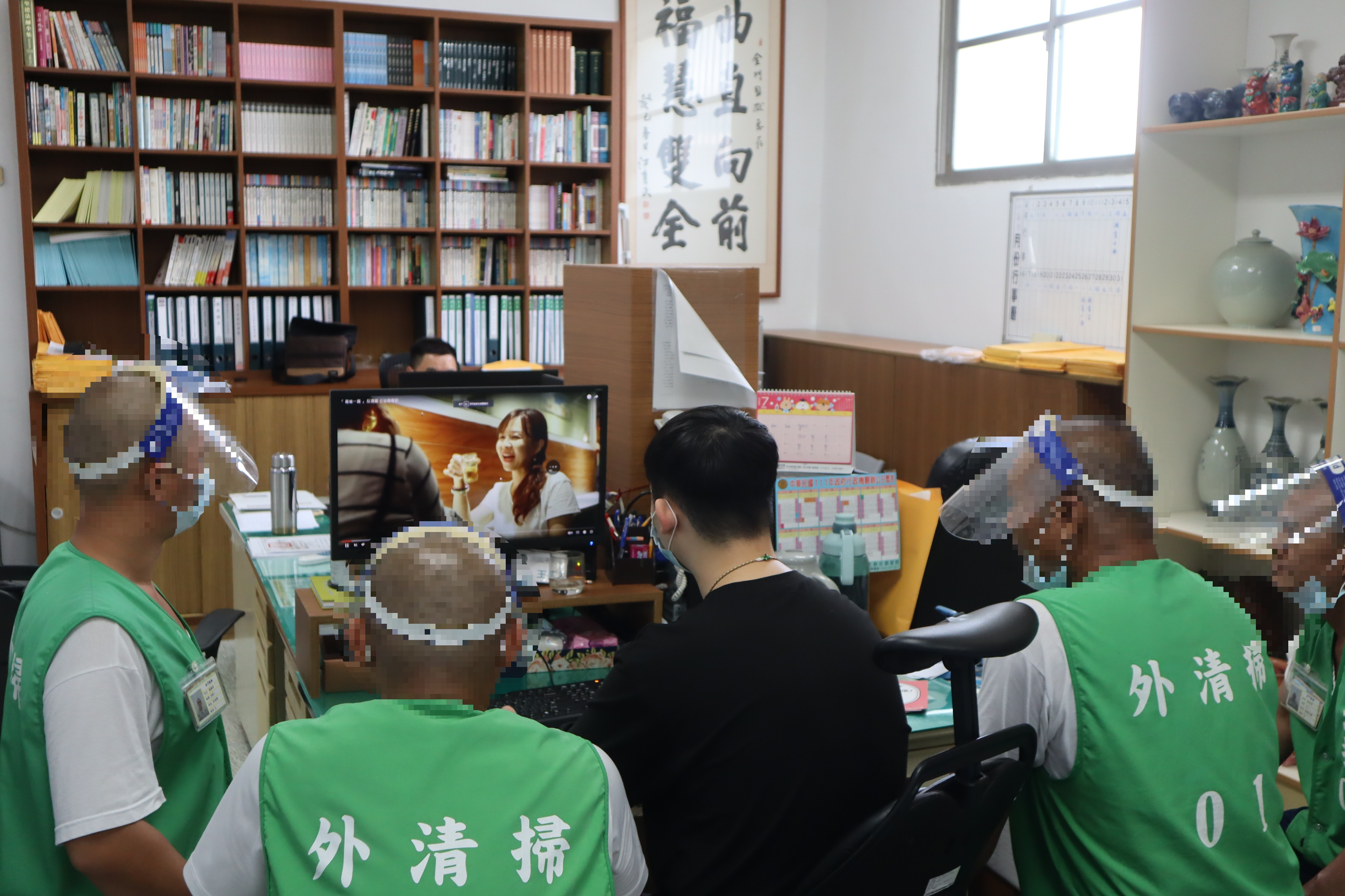 Social workers and inmates watch the promotional video